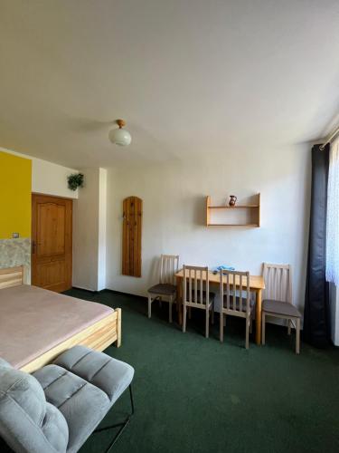 a bedroom with a bed and a table and chairs at Pension Jitka in Harrachov
