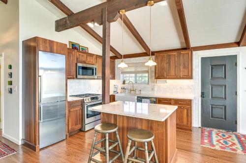 a kitchen with wooden cabinets and a island with bar stools at Cozy Mtn-View Chalet Less Than 2 Mi to Windham Slopes in Windham