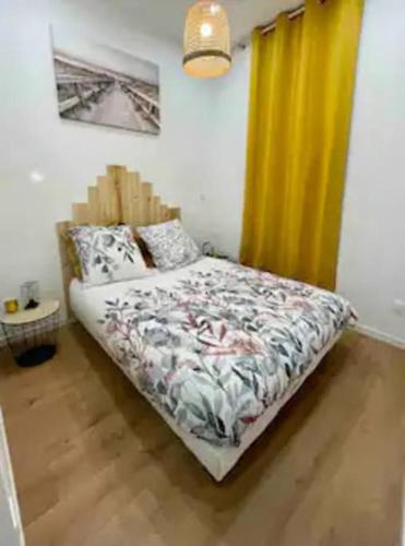 - une chambre avec un lit et un rideau jaune dans l'établissement Coquet T2 proche de la Mairie, à Sète