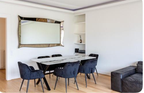 une salle à manger avec une table, des chaises et un miroir dans l'établissement 2 bedroom appartement champs Élysée, à Paris