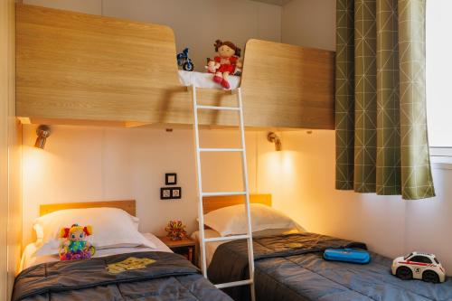 un lit superposé avec une échelle dans une chambre avec deux lits dans l'établissement Camping Park Er Lann, à Saint-Pierre-Quiberon