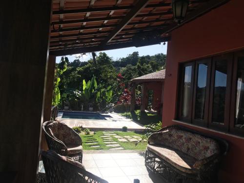 porche con 2 sillas y vistas a la piscina en Sitio Maravilha, en Mulungu