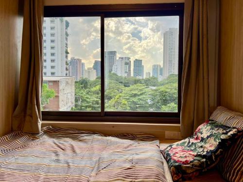a bedroom with a window and a bed in front of it at Comfy Crib Hostel 2 in Bangkok