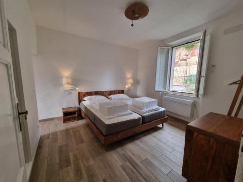 a bedroom with a bed and a window at Panoramico 15 in Massa Marittima