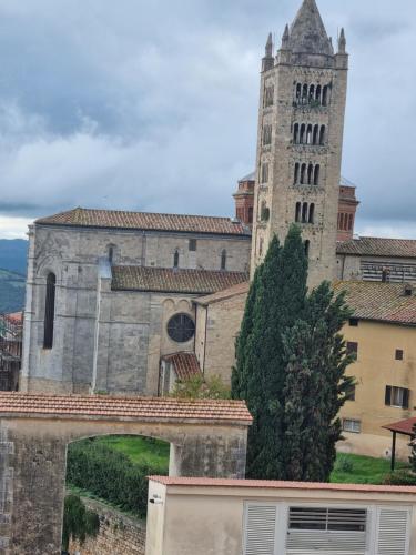 a building with a tower and a clock tower at Panoramico 15 in Massa Marittima
