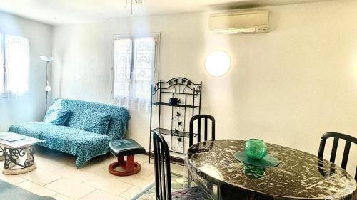 un salon avec une table et une chaise dans l'établissement Rendez-vous au soleil de Provence - gite 4 personnes 80m2 - coin jardin - climatisation, à Cheval-Blanc