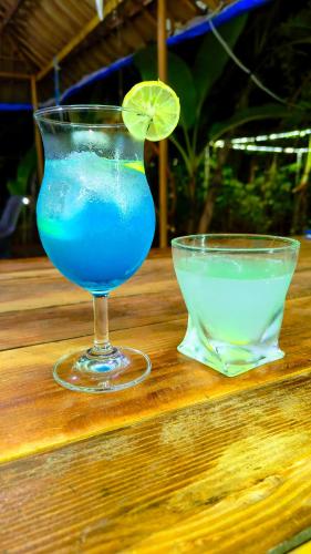 a blue drink in a glass next to a bowl of liquid at Samyama Retreat in Cola