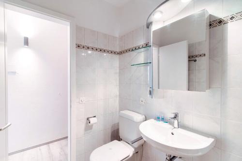 a white bathroom with a sink and a toilet at Castagnola 501 by Quokka 360 - flat with balcony in Lugano