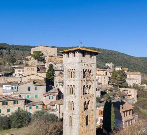 a tall tower in front of a town with a city at Appartamento monolocale con giardino, Siena 15 min in Rosia