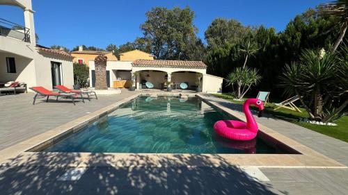 a swimming pool with a pink flamingo in the water at Villa Emeraude-Joyaux de Provence in Saint-Étienne-du-Grès