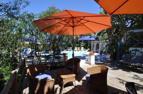 a patio with a table with an orange umbrella at Villa Eva in Anacapri