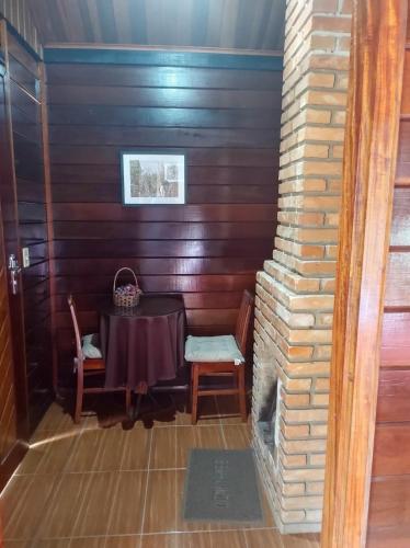 a table and chairs in a room with a fireplace at Pousada Mon Desir in Penedo