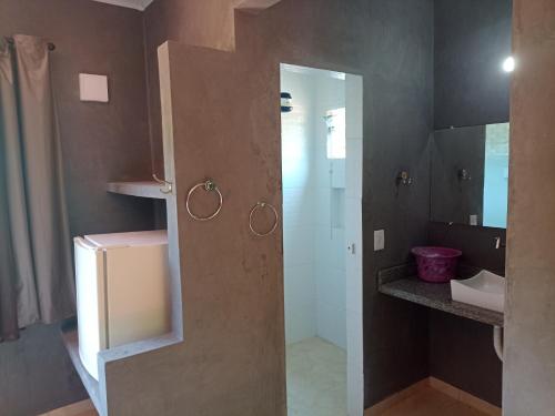 a small kitchen with a refrigerator and a sink at Pousada ZEN Cumuruxatiba in Cumuruxatiba
