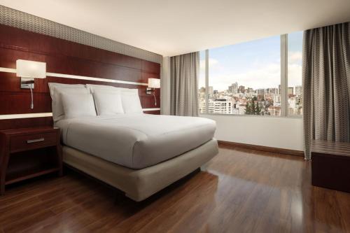 a hotel room with a bed and a large window at JW Marriott Quito in Quito
