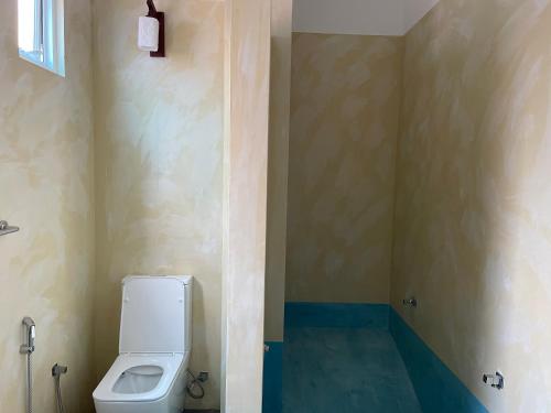 a bathroom with a toilet in the corner at Marigold Negombo in Negombo