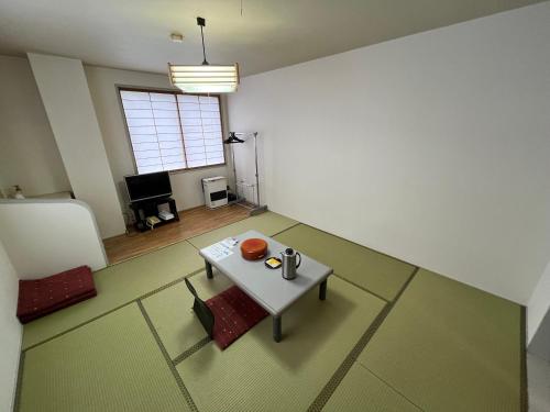 a living room with a table and a couch and a table at Hotel Yuzawa Yuzawa Denkiya in Yuzawa