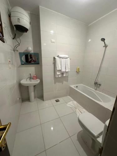 a bathroom with a sink and a tub and a toilet at Eka- Guesthouse in Aswan