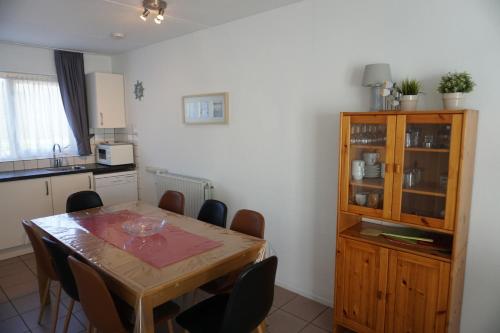 a kitchen with a wooden table and chairs in a room at Kustverhuur, Vakantiepark Fort Soleil 52 in Breskens