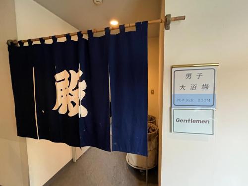 a blue curtain in a room with a sign at Hotel Yuzawa Yuzawa Denkiya in Yuzawa