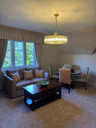 a living room with a couch and a table at Macdonald Berystede Hotel & Spa in Ascot