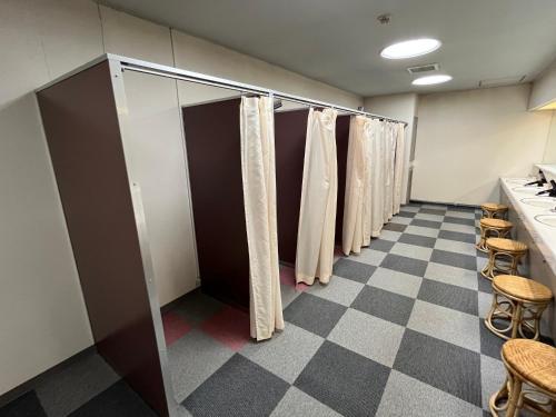 a row of stalls in a dressing room with curtains at Hotel Yuzawa Yuzawa Denkiya in Yuzawa