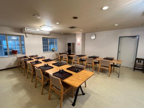 a conference room with wooden tables and chairs at Hotel Yuzawa Yuzawa Denkiya in Yuzawa
