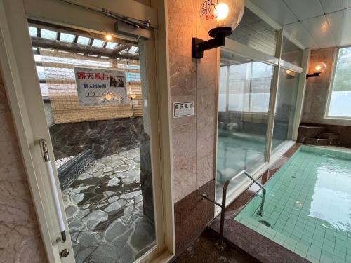 a bathroom with a swimming pool and a shower at Hotel Yuzawa Yuzawa Denkiya in Yuzawa