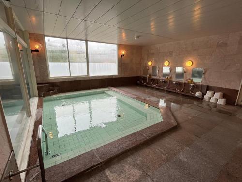 a large swimming pool in a room with at Hotel Yuzawa Yuzawa Denkiya in Yuzawa