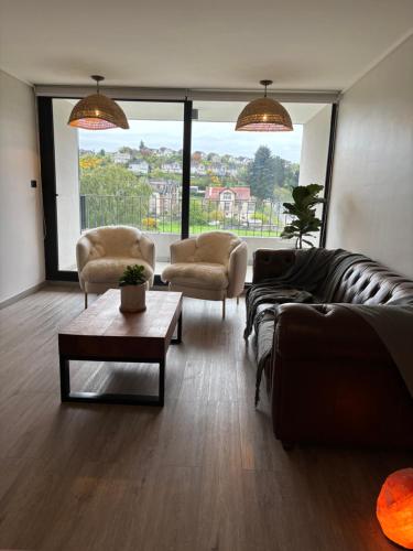 a living room with a couch and two chairs and a table at The Roses in Puerto Varas