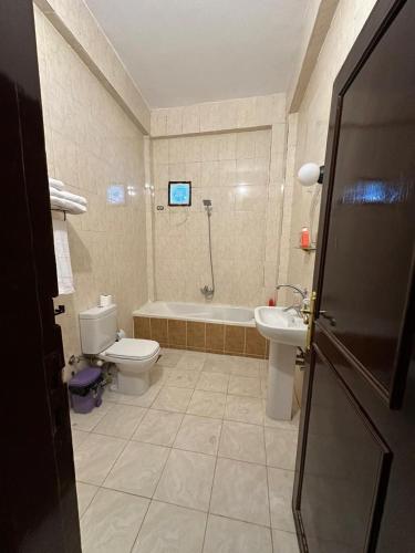 a bathroom with a tub and a toilet and a sink at Eka- Guesthouse in Aswan