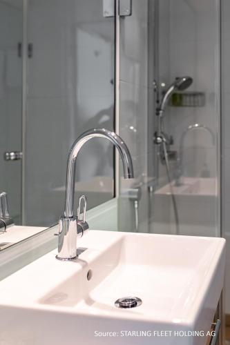 a bathroom sink with a mirror and a shower at Hotelship KD Moment Köln in Cologne