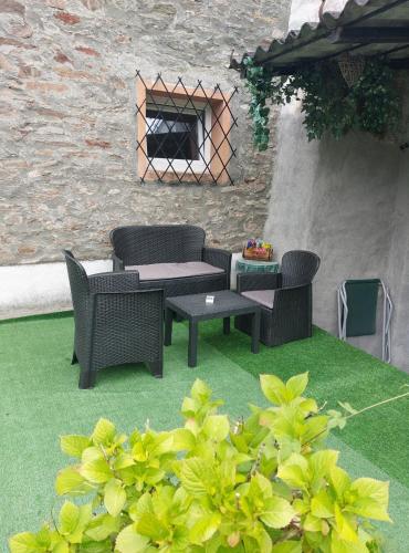 a patio with a table and chairs on grass at Le Glacier in La Salle