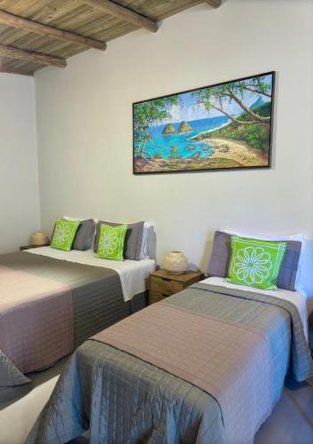 a room with two beds and a picture on the wall at Pousada Cheiro Verde Noronha in Fernando de Noronha