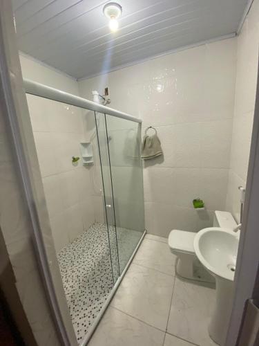 a bathroom with a shower and a toilet and a sink at Recanto Remanso in Queimados