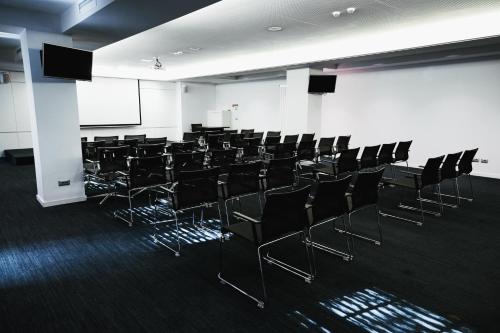 a conference room with black chairs and a white wall at Il Decameron Luxury Design Hotel in Odesa