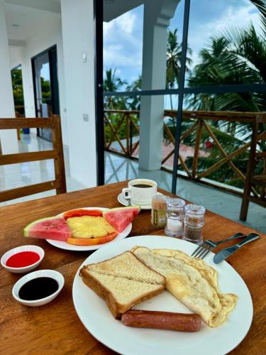a table with a plate of bread and toast at Rafiki Hotel Nungwi Beach in Nungwi