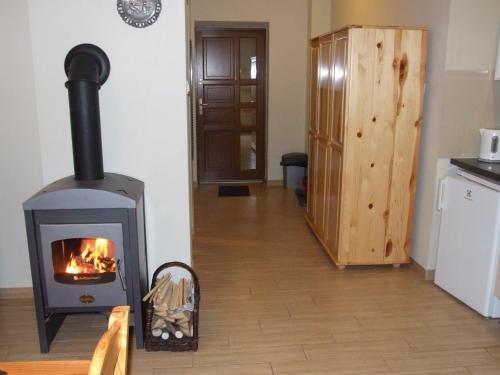 a wood stove in a room with a kitchen at Pokoje i apartamenty pod Jaworzyną w Koninkach in Koninki