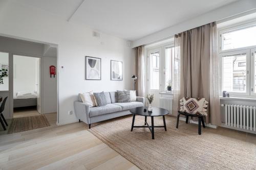 a living room with a couch and a table at "PENTHOUSE" - Renovated 1BR Apt with Sauna & 60m2 Private Terrace, Hosted by 2ndhomes in Tampere