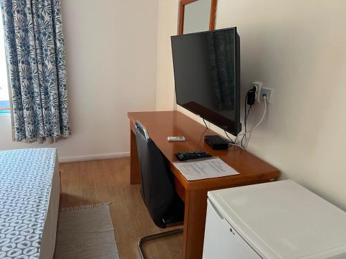 a bedroom with a desk with a computer monitor on it at Art House in Luanda