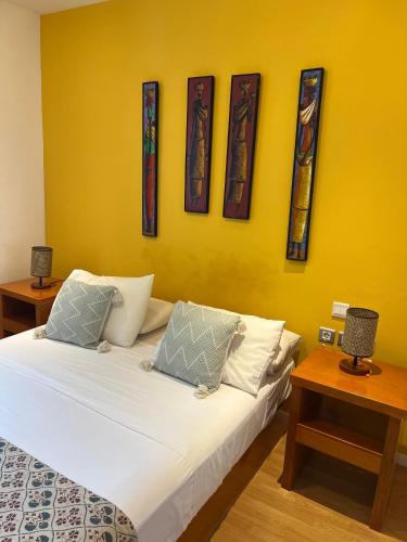 a bedroom with a bed and a yellow wall at Art House in Luanda