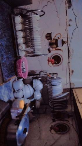 a dirty room with a bunch of dishes on a wall at Glorious Guest House & Hotel in Multan