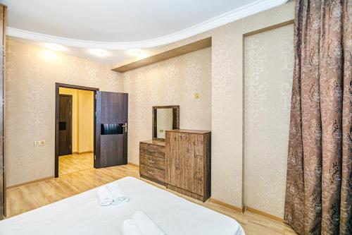 a bedroom with a bed and a dresser and a mirror at Magnificent Vacation apartment by Bea Paradise in Baku