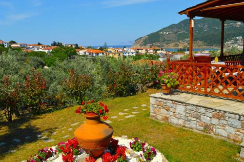 a vase filled with flowers in a yard with avisor at Remvi Apartments in Skopelos Town