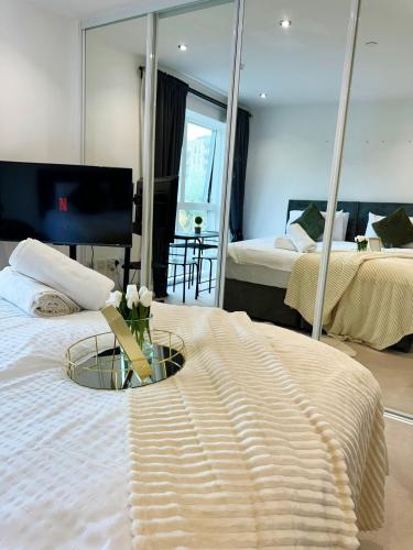 a bedroom with two beds and a mirror at Kayz Lodge- Luxury Ensuite-Private & Shared Accommodation in a New House at the Olympic village overlooking Stratford Westfield and Tube Station in London