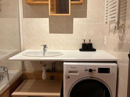La salle de bains est pourvue d'un lave-linge et d'un lavabo. dans l'établissement Appartement 2 pièces cabine 3* pour 6 pers avec piscine, balcon et parking privé, proche télésiège - FR-1-263-408, à Valloire