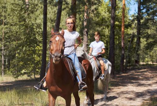 a woman and a child riding on a horse at Mons Arachova in Arachova