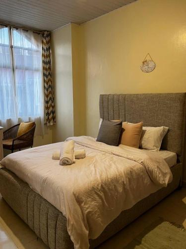a large bed in a room with a window at Ramshab apartments A8 in Nairobi