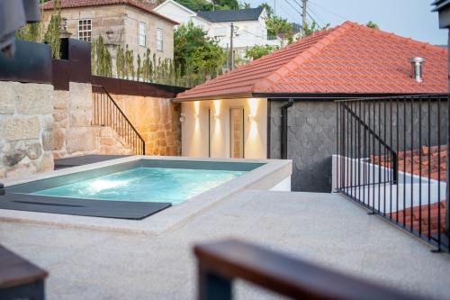 a swimming pool on a patio with a house at Feel Discovery Casa de Cima Douro Valley in Riba Douro