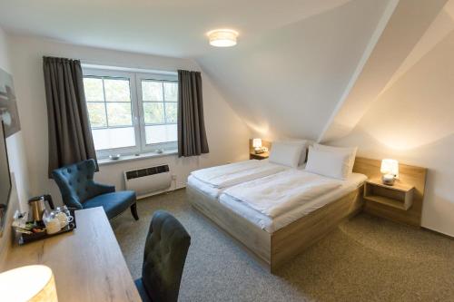 a bedroom with a bed and a desk and a chair at Cuxlandhotel Studio 124 in Dorum Neufeld