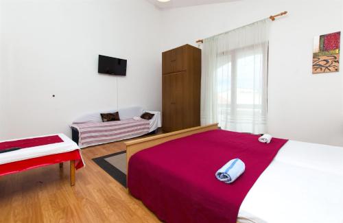 a bedroom with a large bed with a red blanket at Apartments Neva in Sumpetar